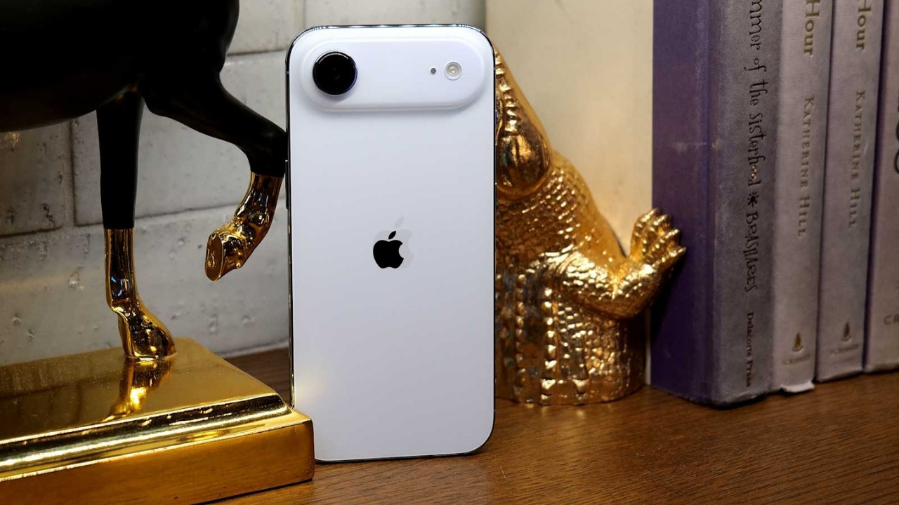 White iPhone Air rear design with single camera placed on a desk beside books and decorative items
